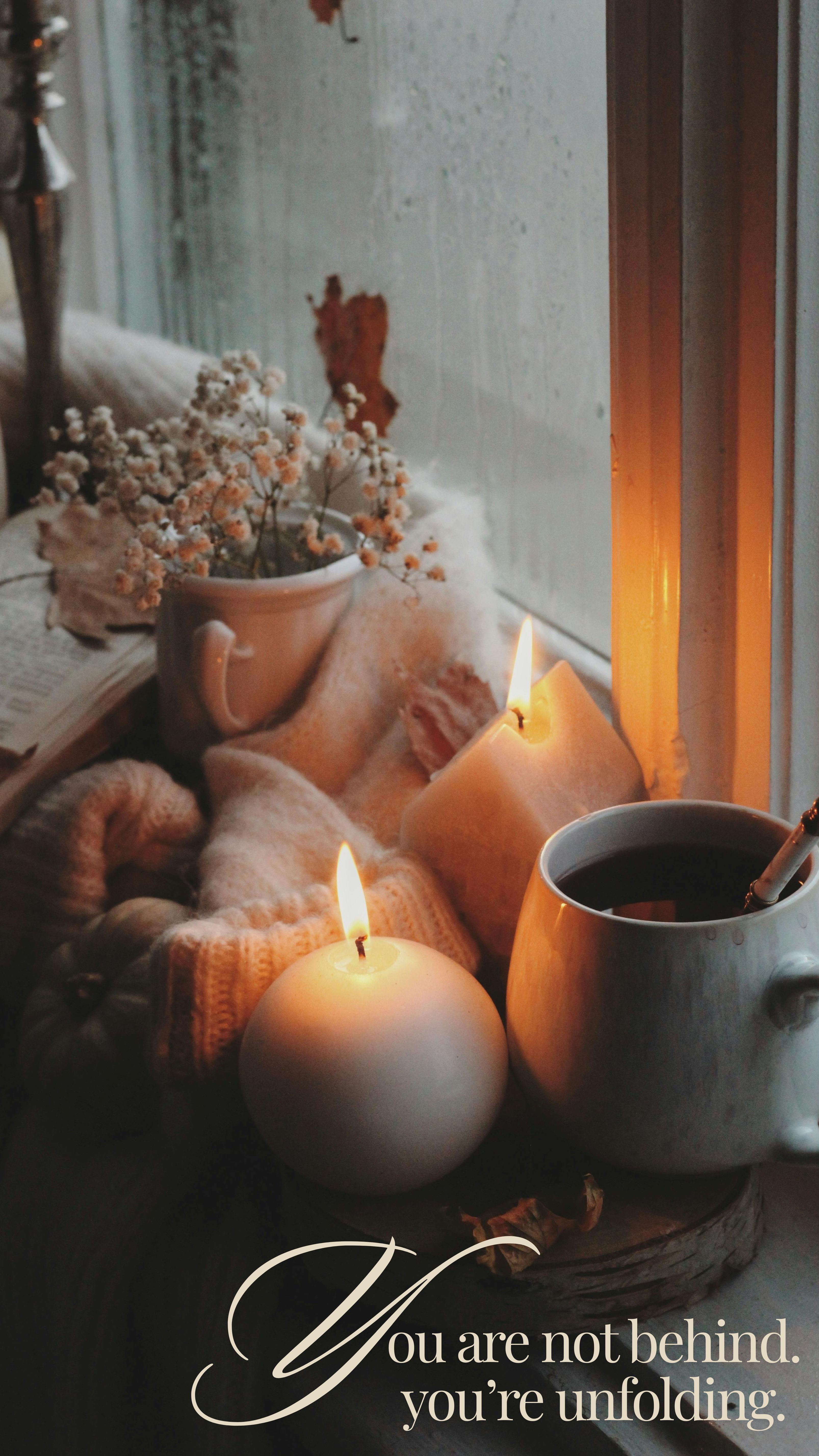 Cozy scene with candles, tea, and dried flowers - you are unfolding